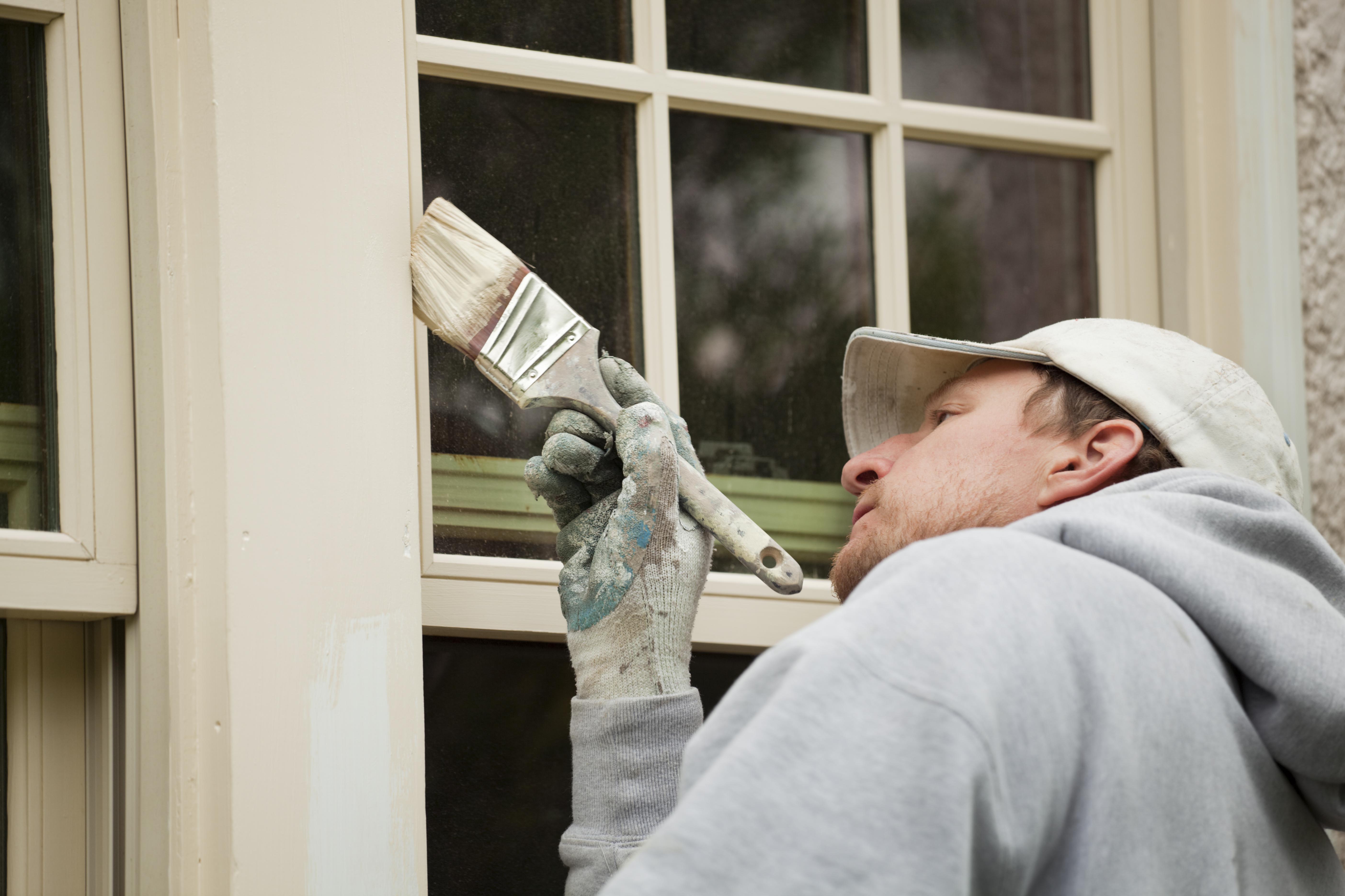 Painter treating and painting external windows