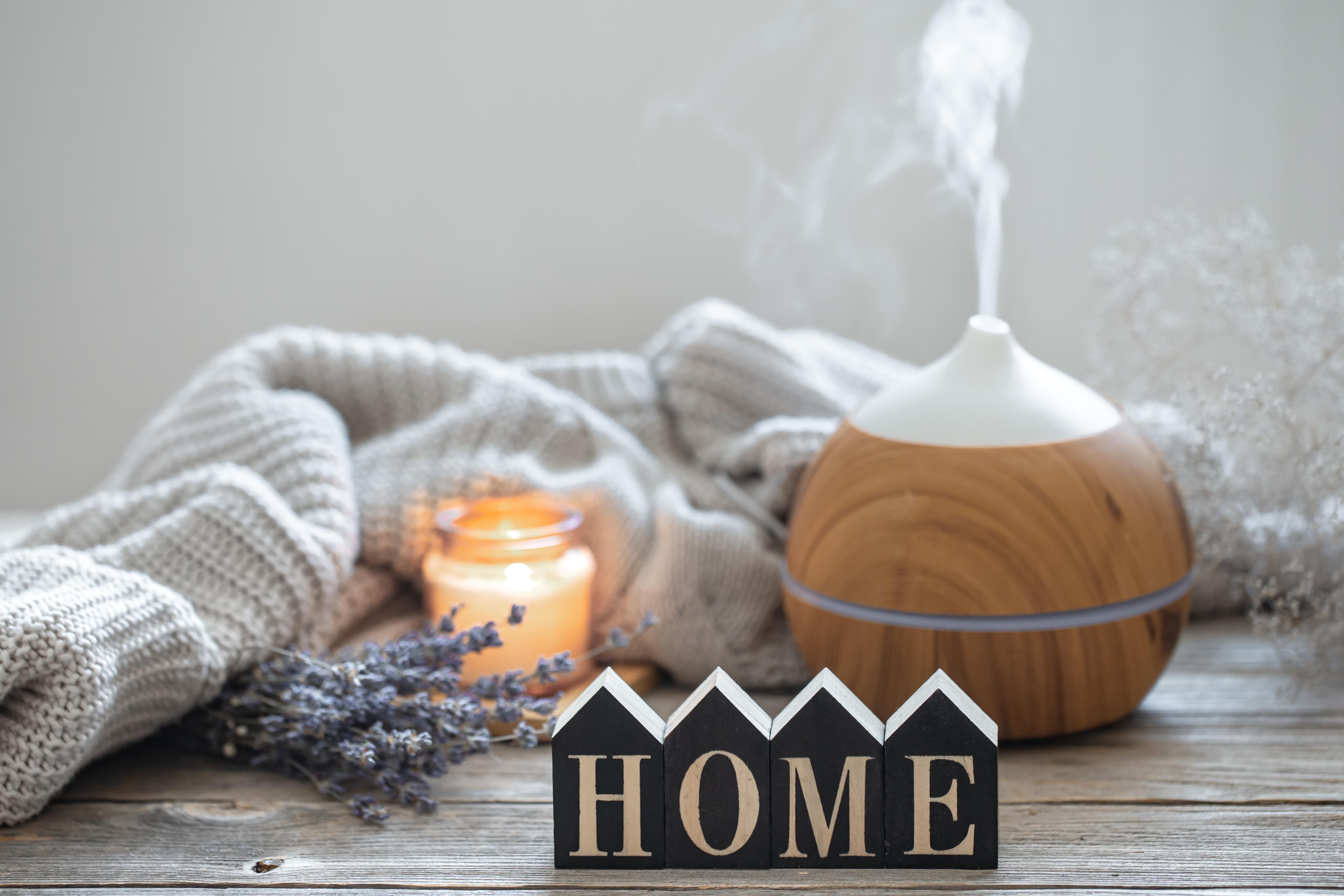 cozy home composition with air humidifier diffuser and scented candles