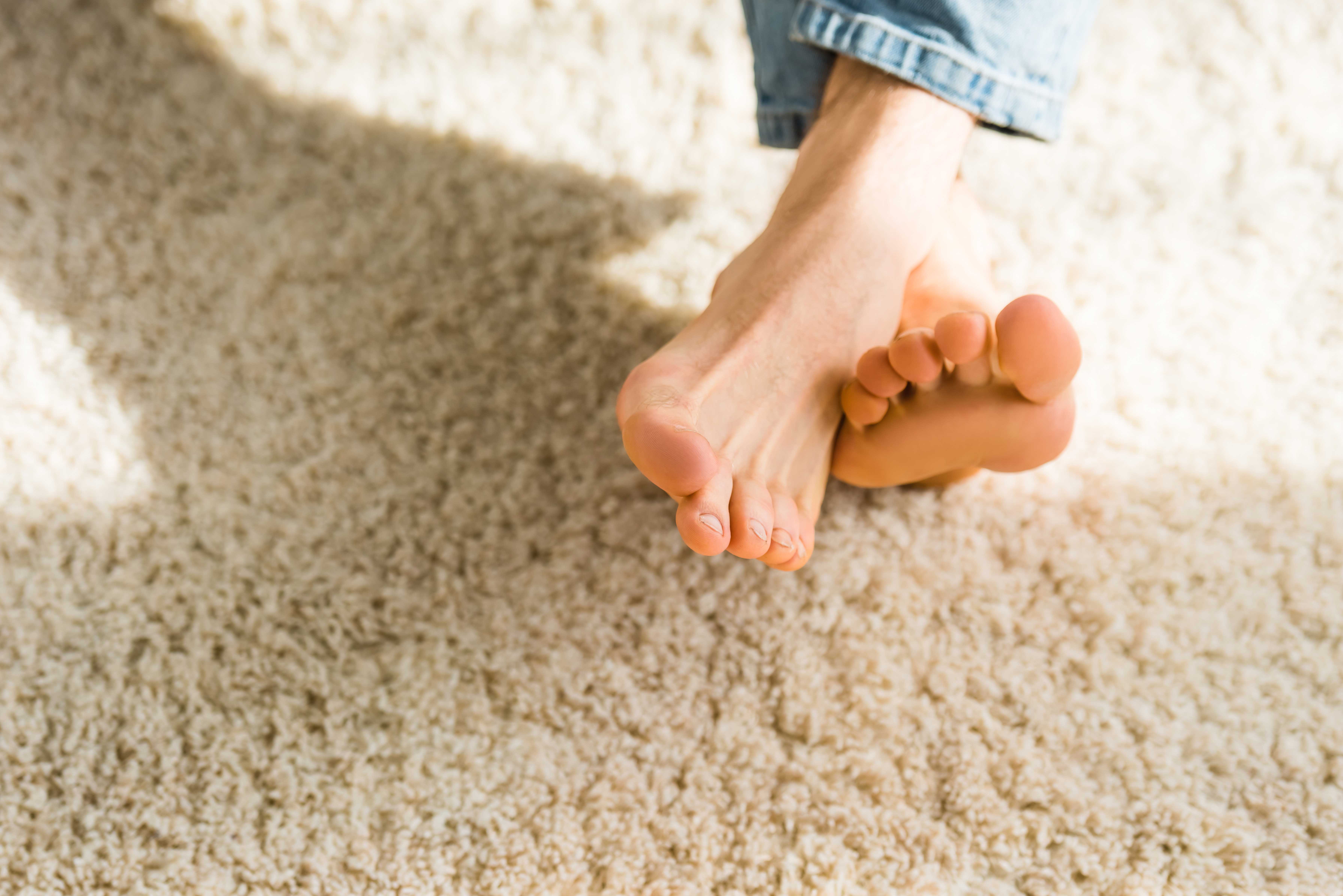 male feet on beige rug