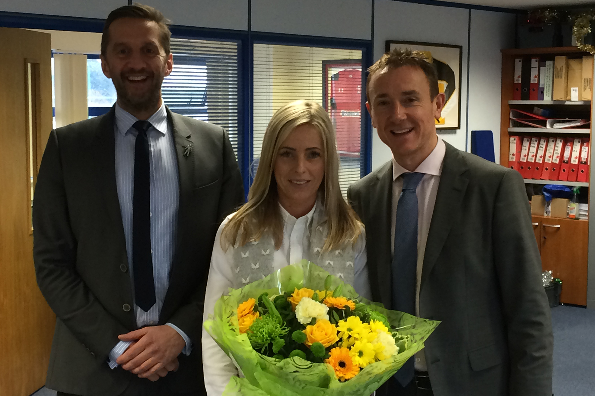 Simon Trippett (Director) and Steve Jones (Partner) presenting Victoria Anderson (Social Media Marketing Executive) with flowers on her 10 year anniversary at The Property Centre